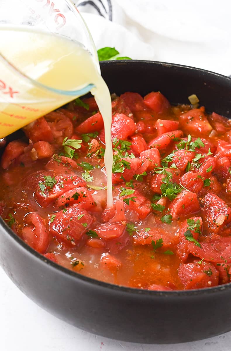 adding chicken broth to tomatoes