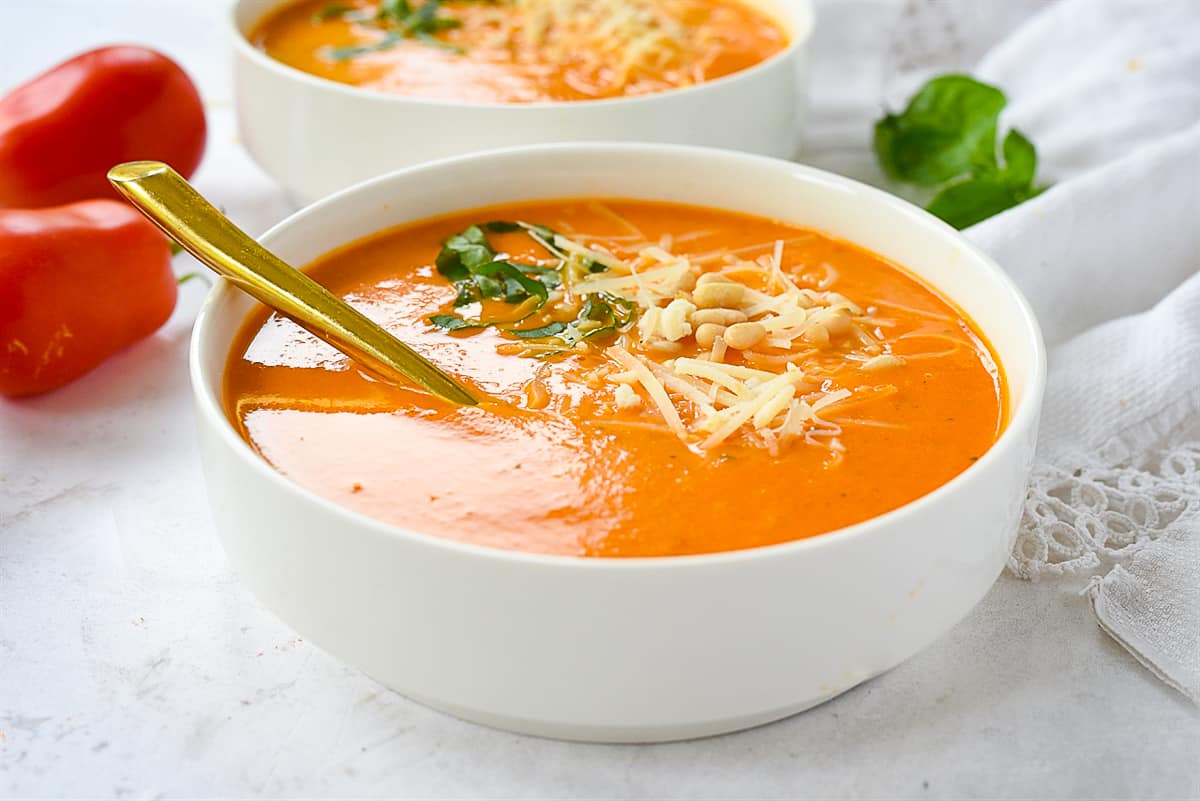 bowl of tomato soup with cheese on top