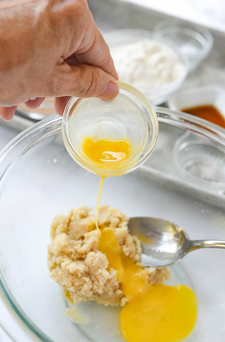 pouring egg into cookie batter
