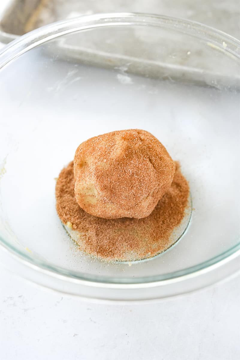 rolling dough into cinnamon sugar