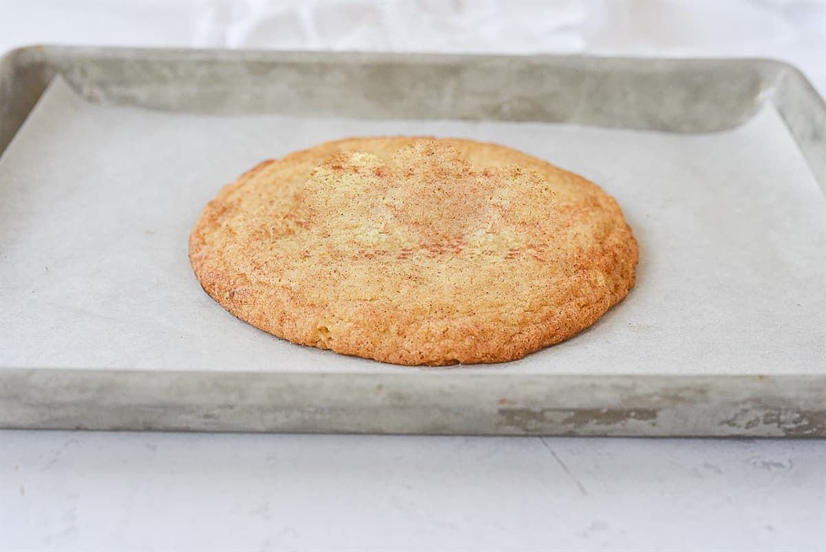 big snickerdoodle cookie on baking sheet