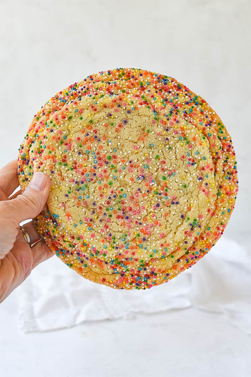 giant sugar cookie hand holding sugar cookie with sprinkles