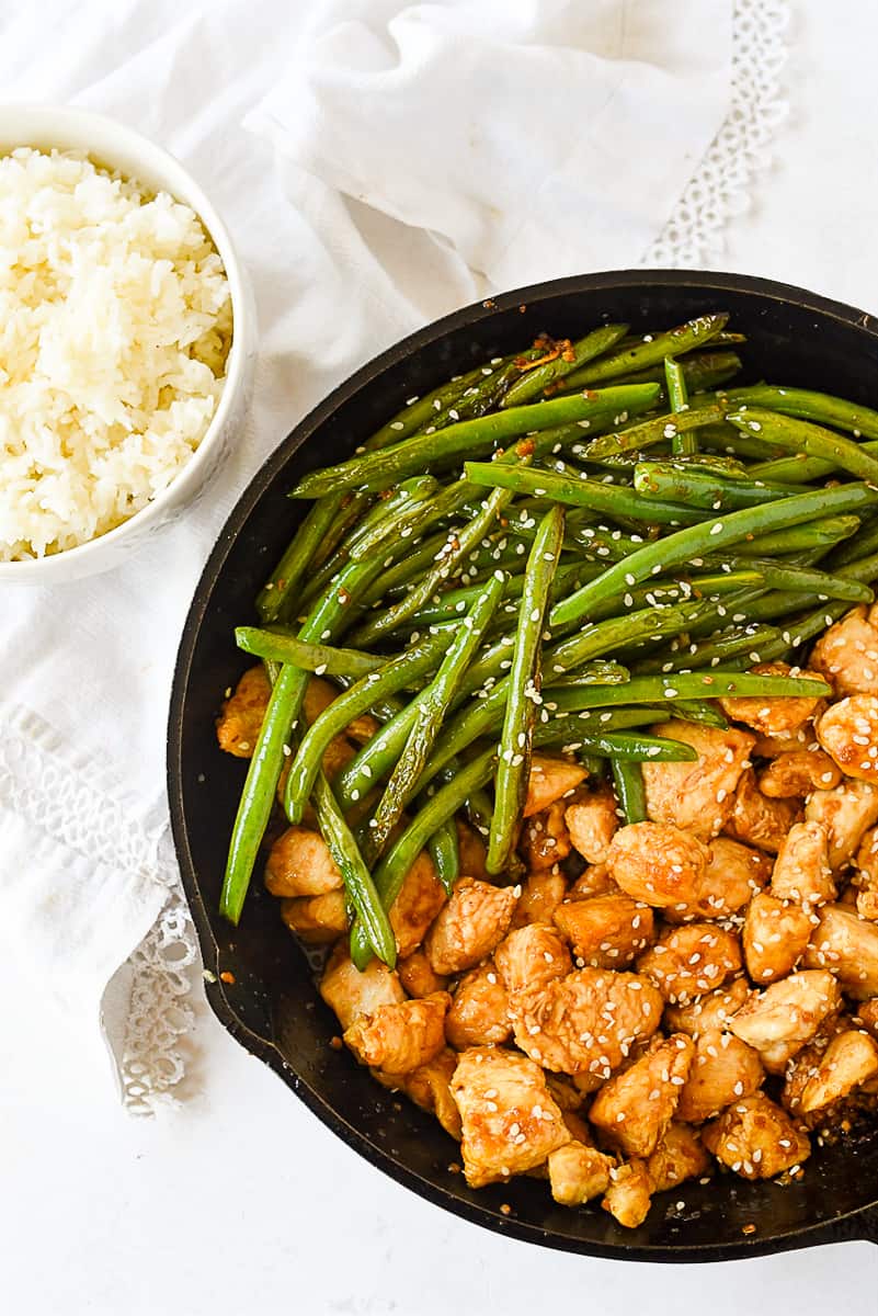 stir fry chicken and beans with a bowl of rice