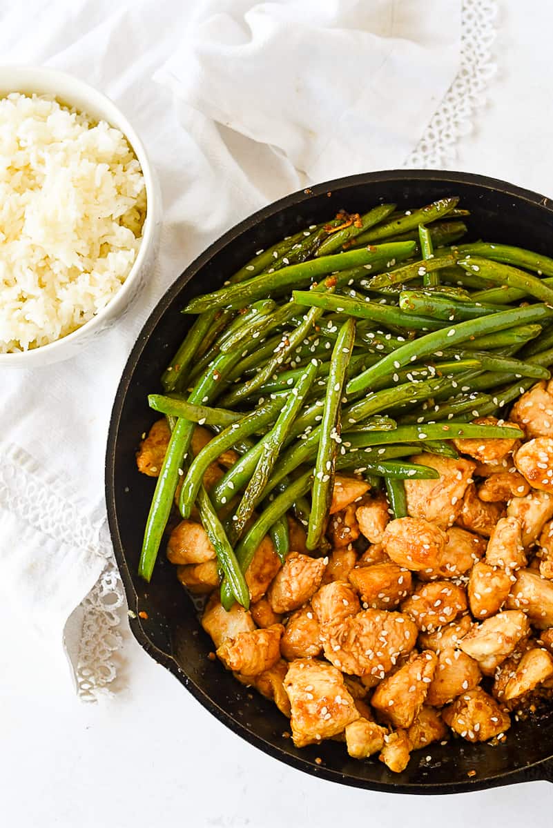 stir fry chicken and beans with a bowl of rice