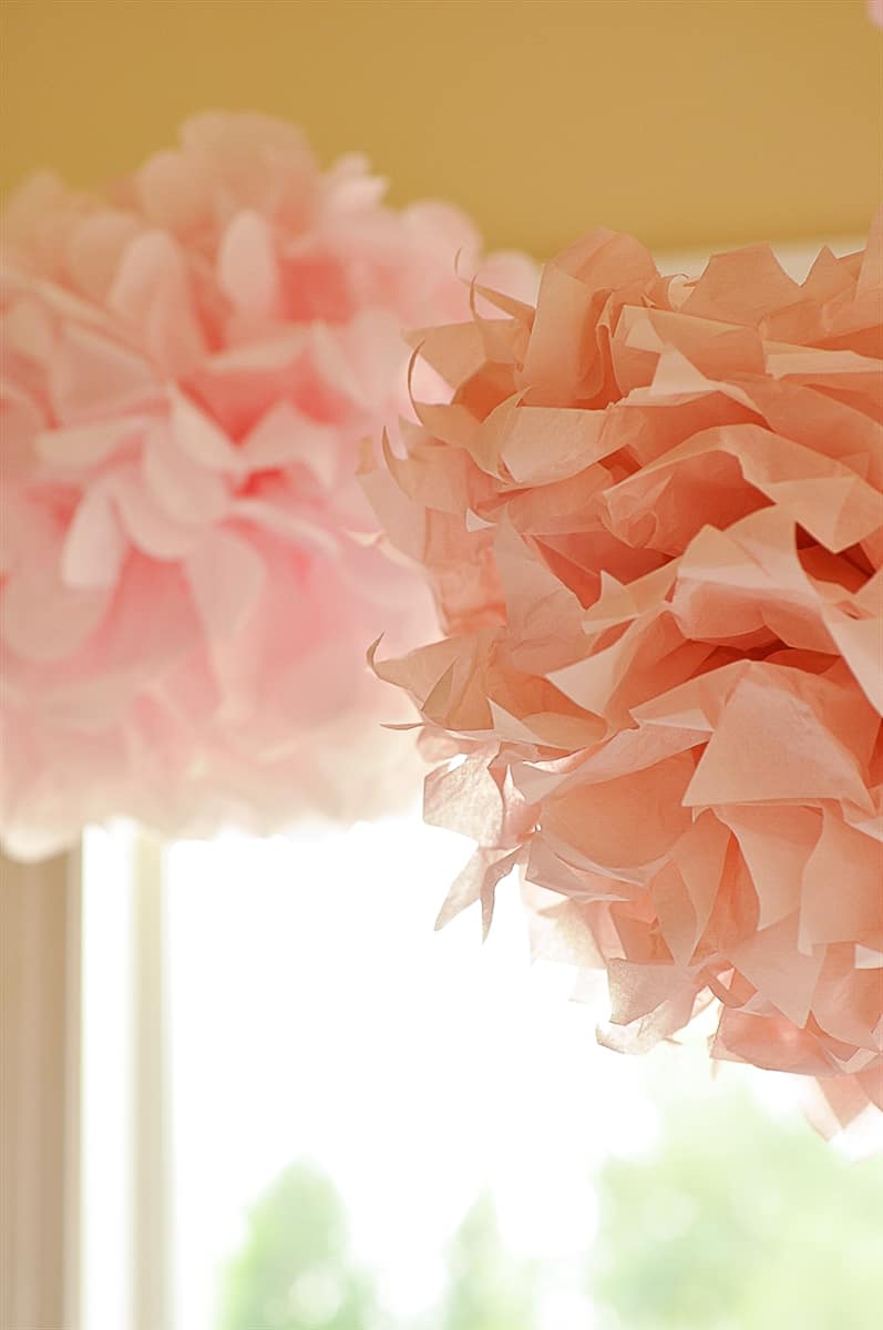 pink pom poms hanging from ceiling