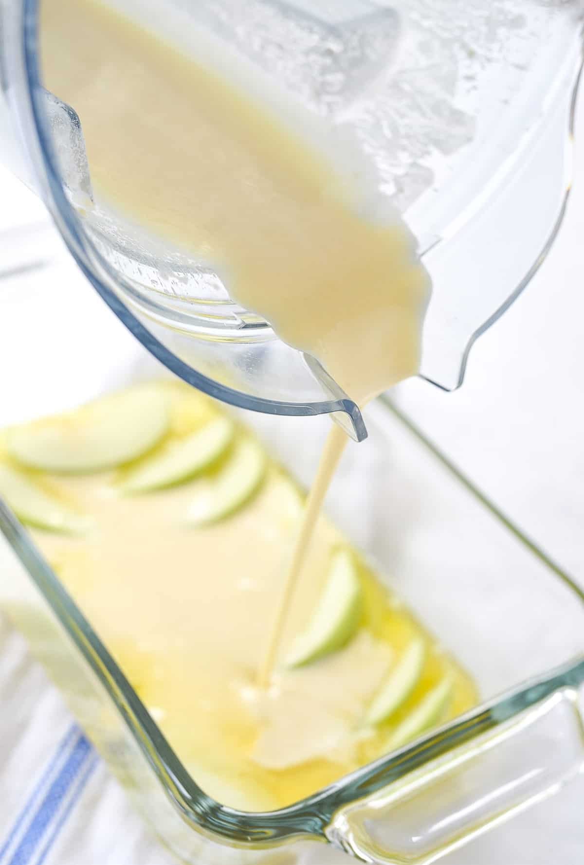 pouring batter over apples