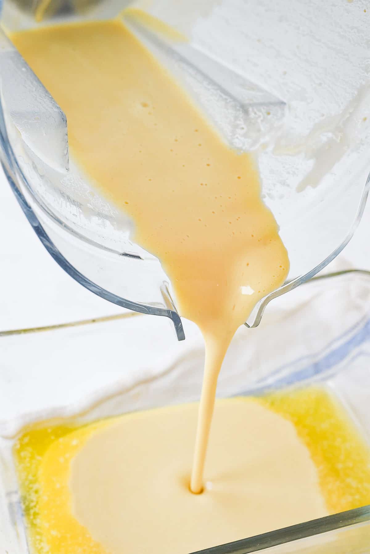 pouring german pancake batter into pan