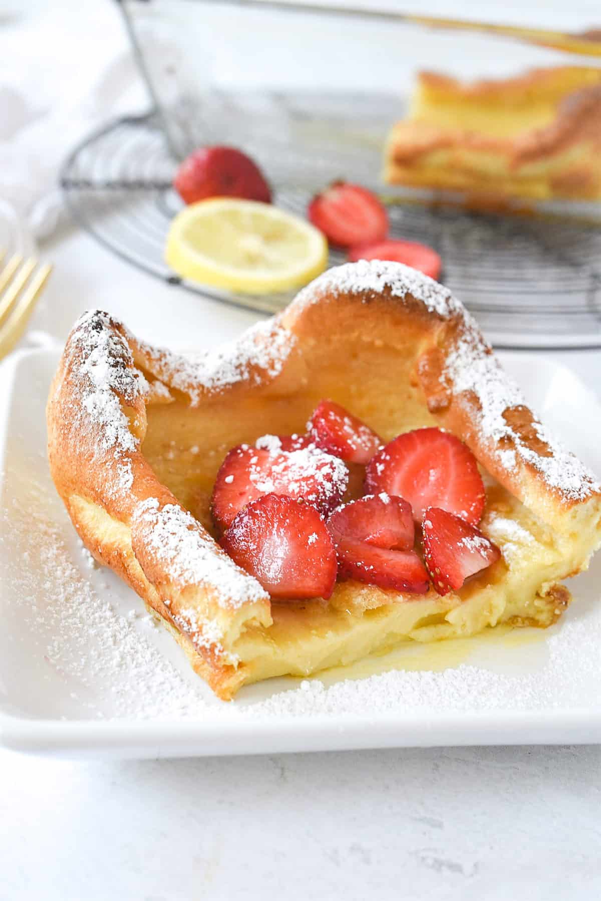 slice of dutch baby pancake with strawberries on top