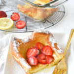 slice of dutch baby with strawberries on top