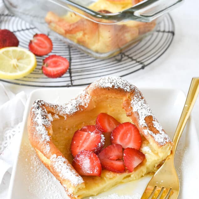 slice of dutch baby with strawberries on top