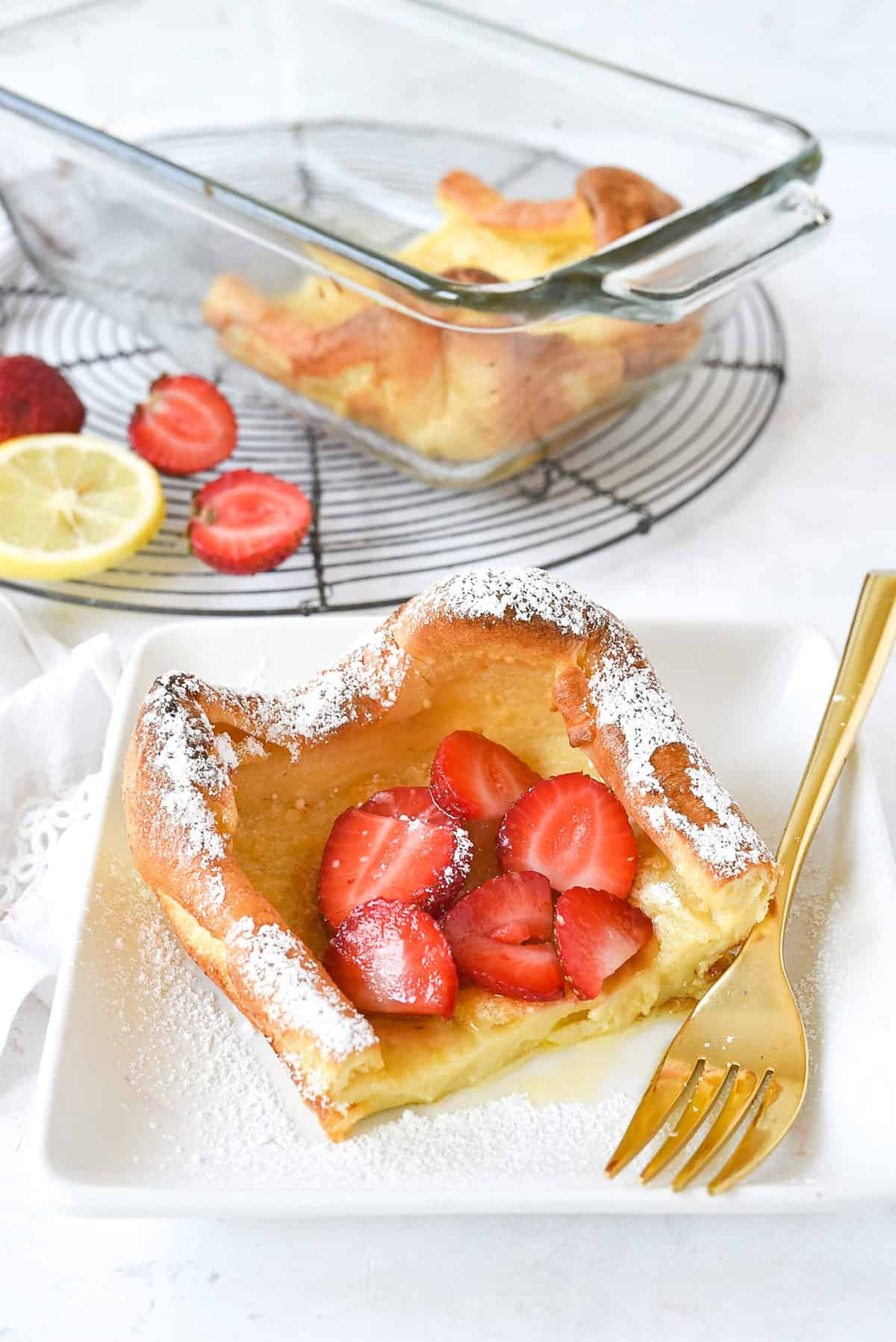 slice of dutch baby with strawberries  on top