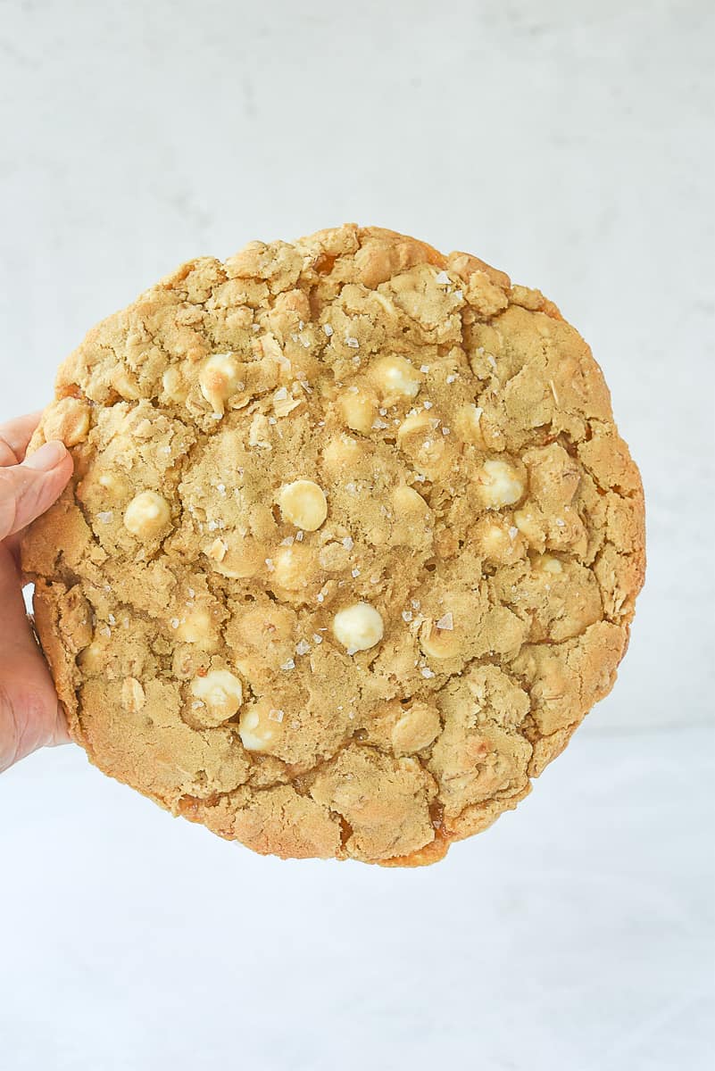 hand holding a salted white chocolate chip oatmeal cookie