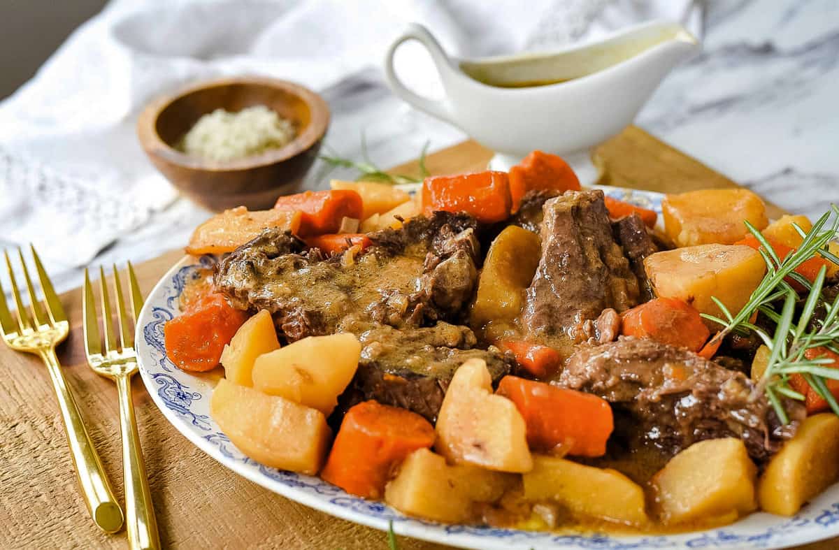 pot roast on a plate with carrots and potatoes