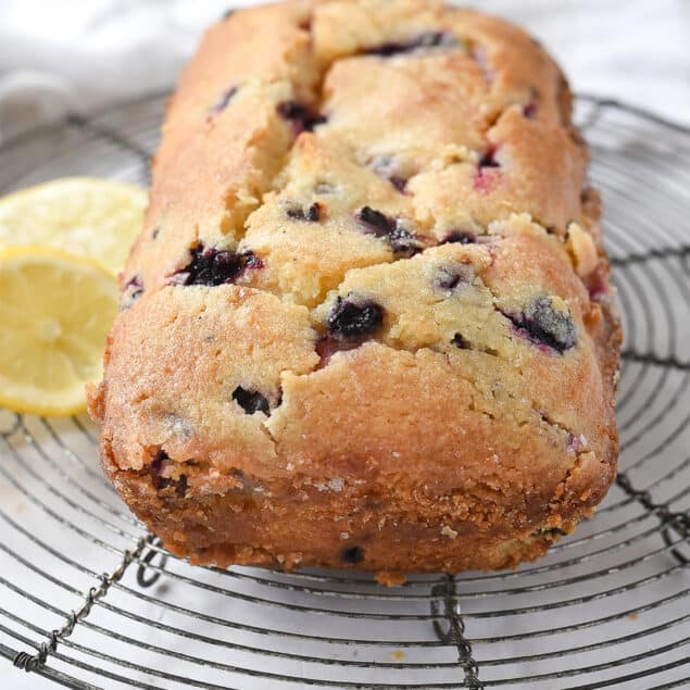 loaf of blueberry bread cooling on a rack