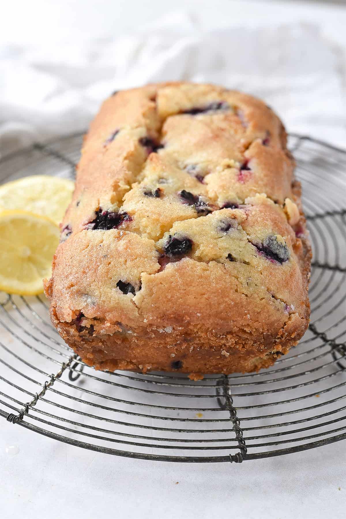 loaf of blueberry bread cooling on a rack