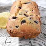 a loaf of blueberry bread on a cooling rack