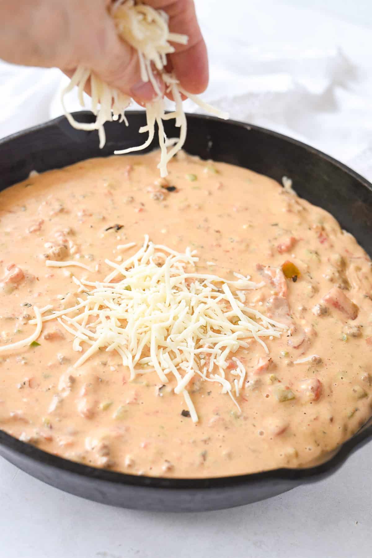 sprinkling cheese on top of queso dip