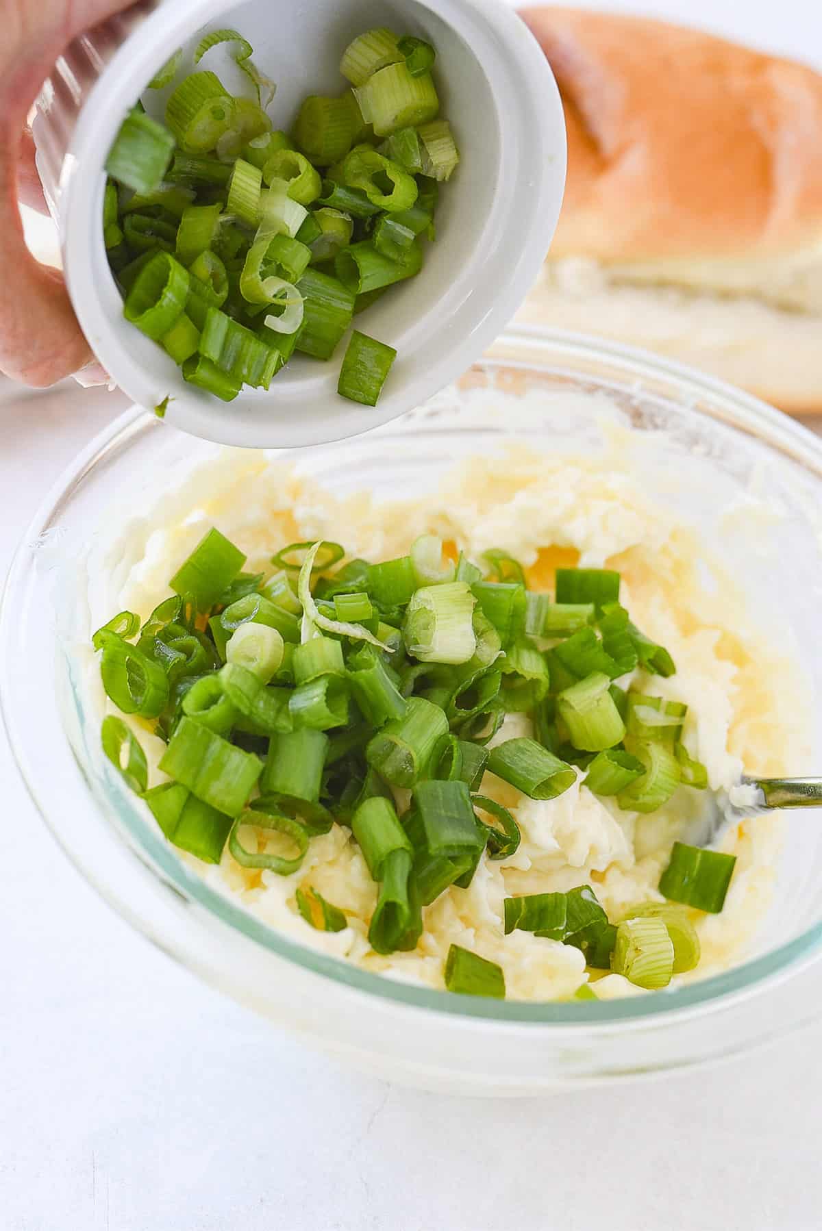 adding green onions to bowl