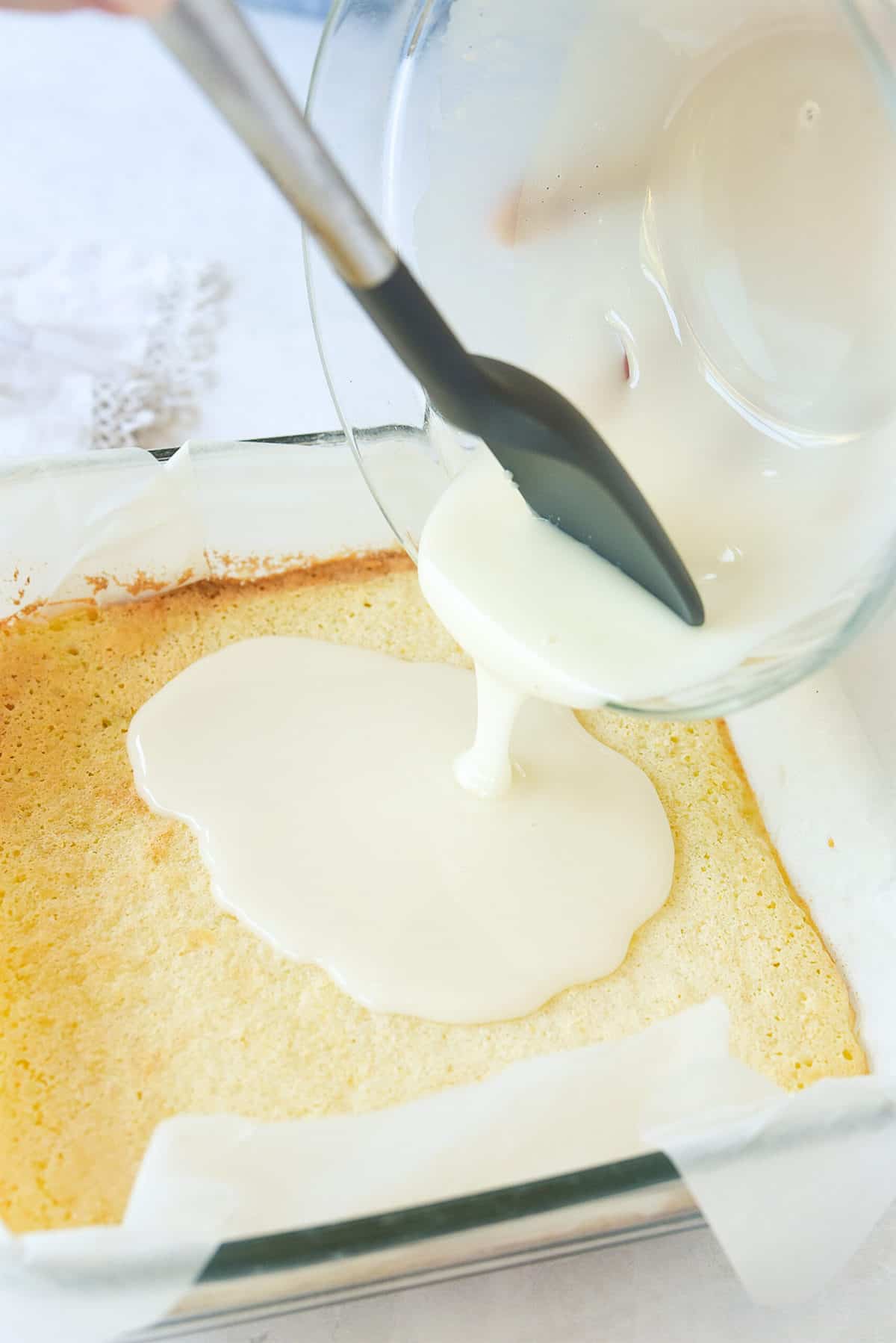 pouring lemon bar filling over shortbread