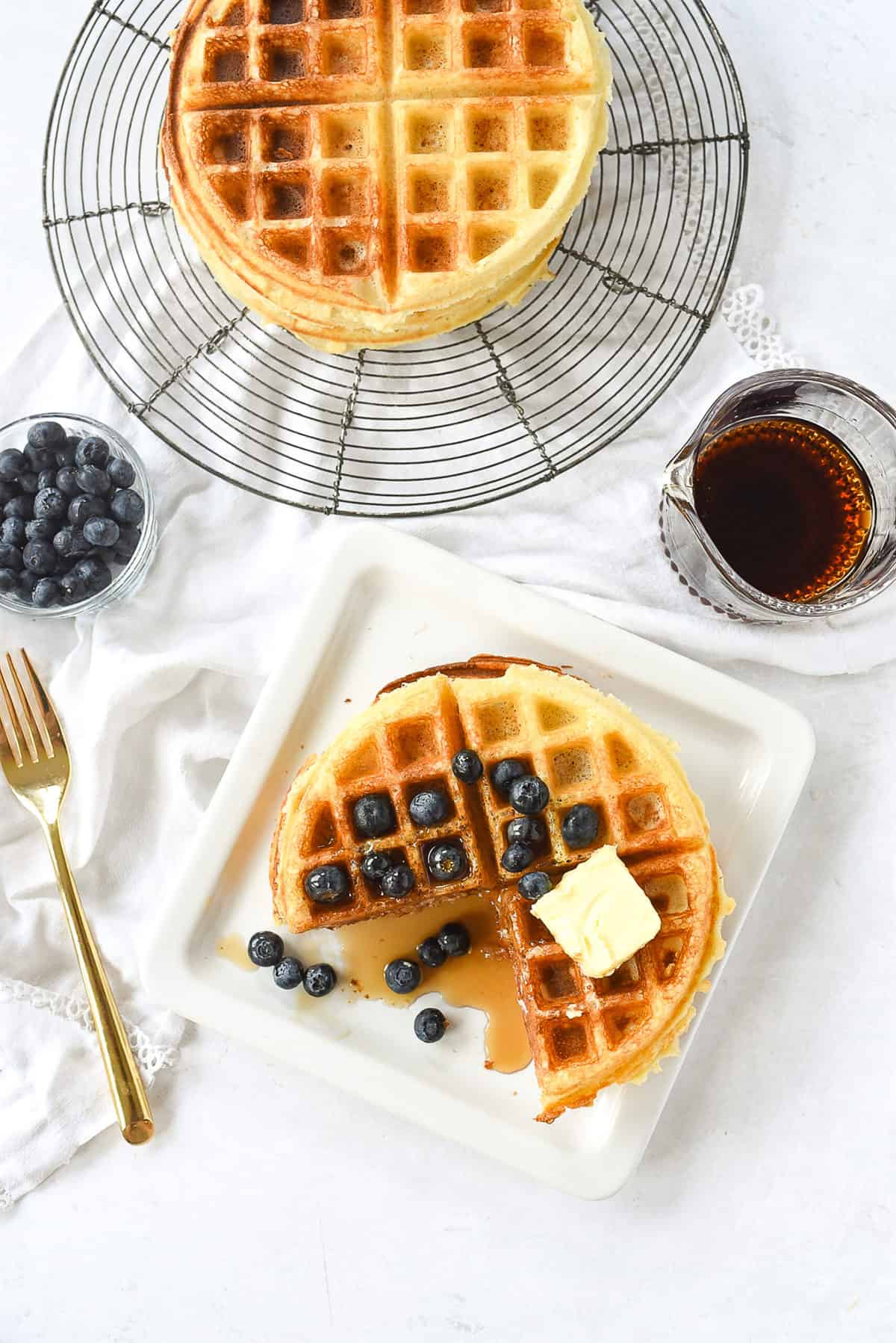 overhead shot of waffles on a plate with blueberries on top.