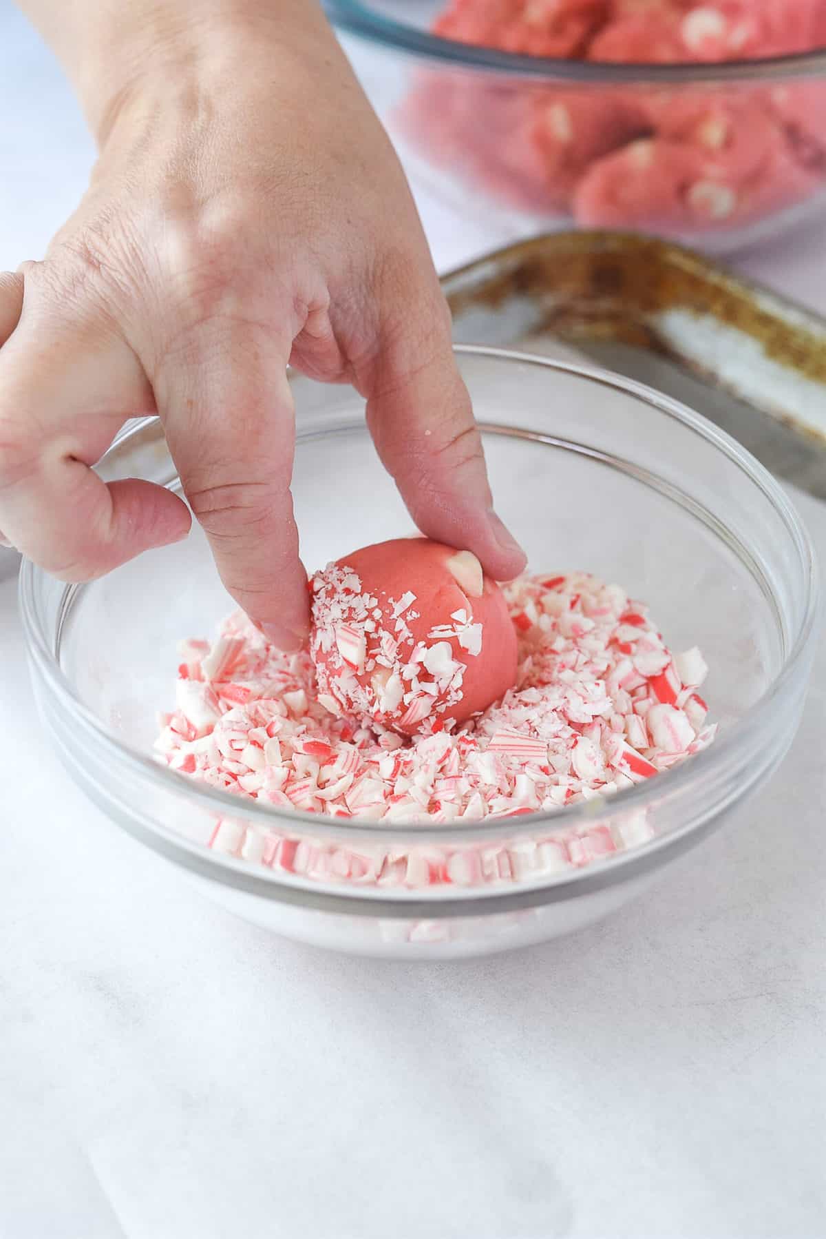 rolling cookie dough into crushed peppermint