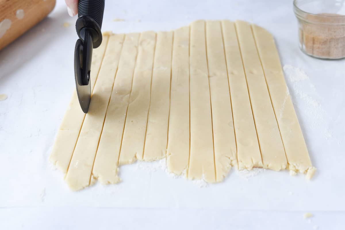 cutting dough with pizza cutter