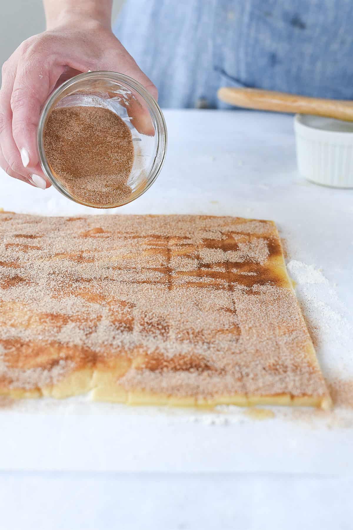 sprinkling pie dough with cinnamon sugar