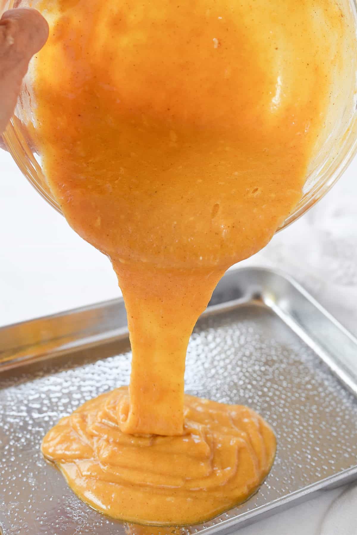 pouring pumpkin bar batter into pan