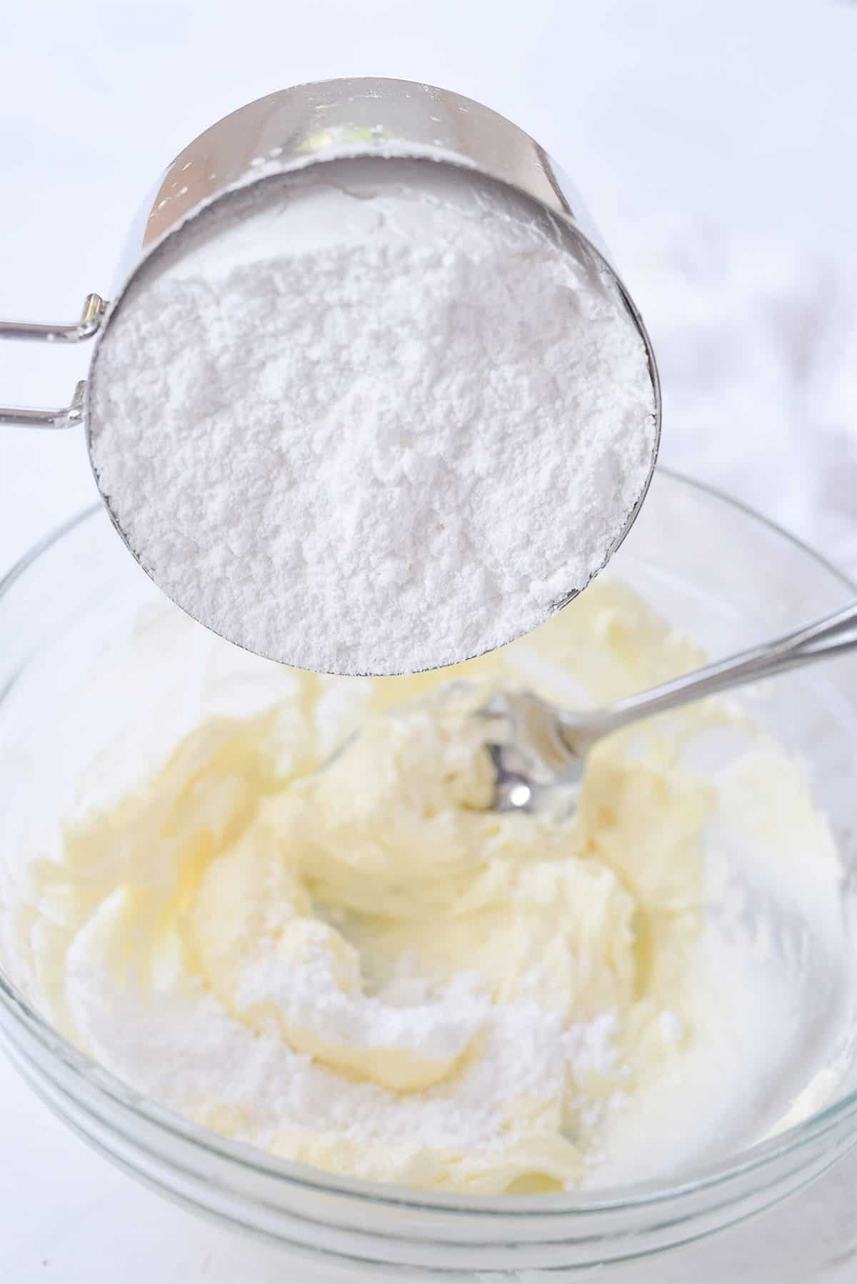 adding powdered sugar to frosting