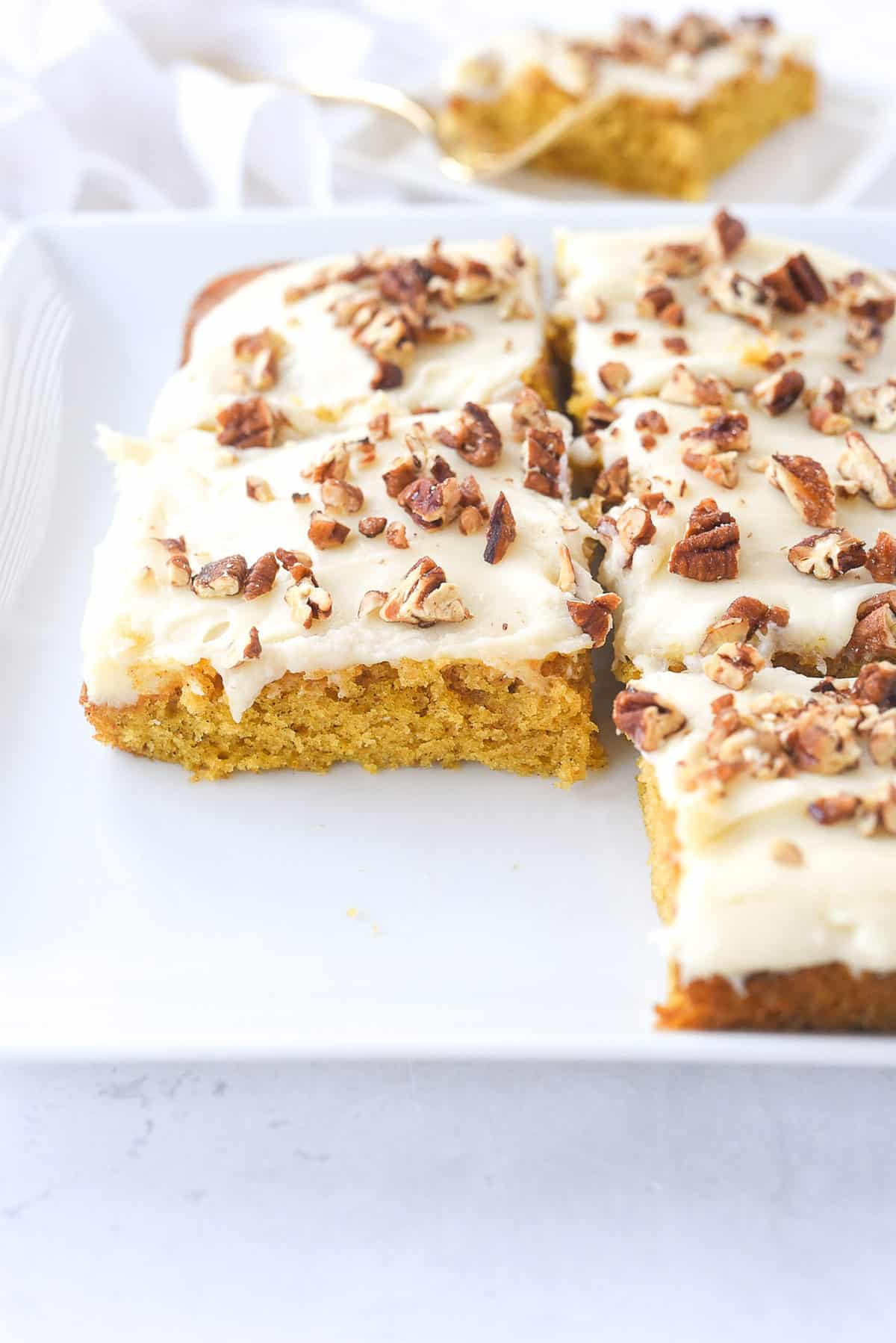 sliced pumpkin bars on a white plate.