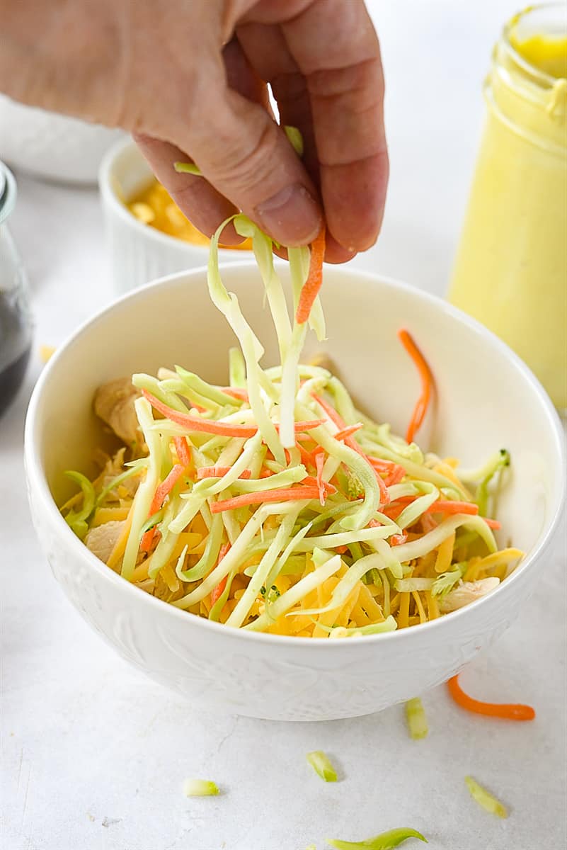 adding broccoli slaw to yumm bowl