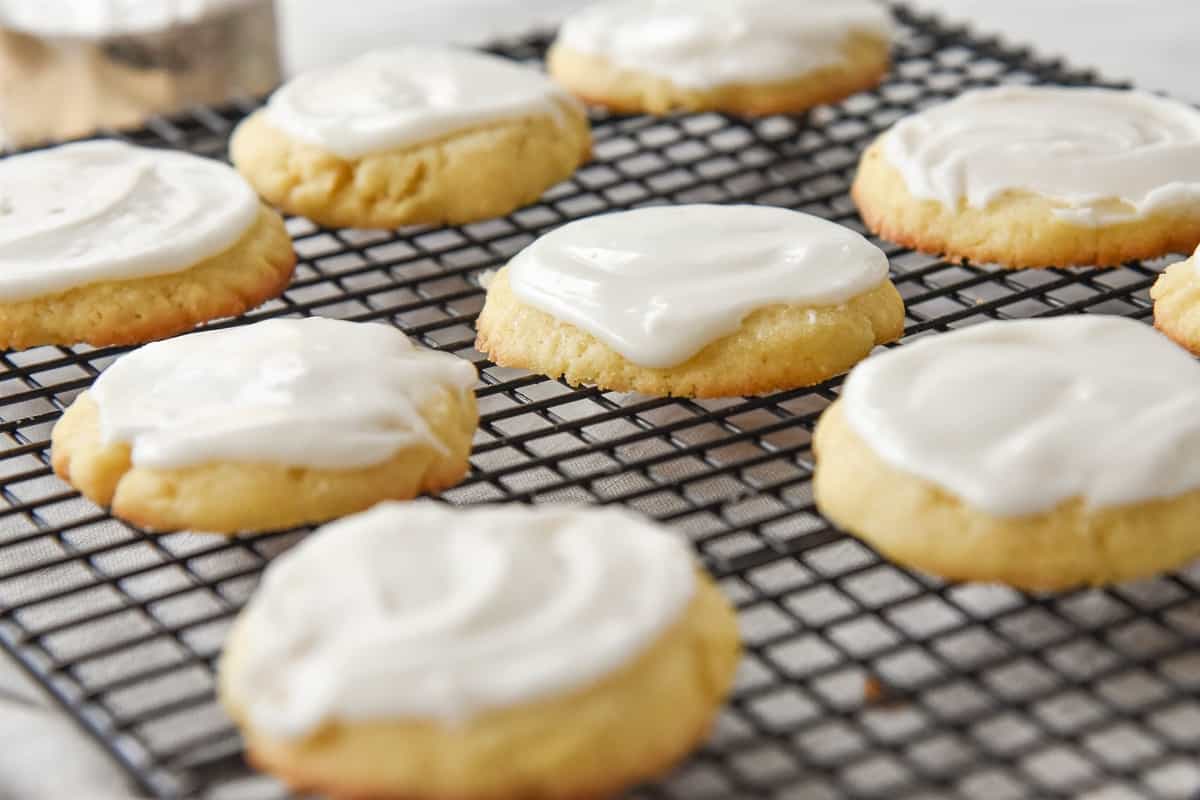 frosted almond cookies on a cooling rack
