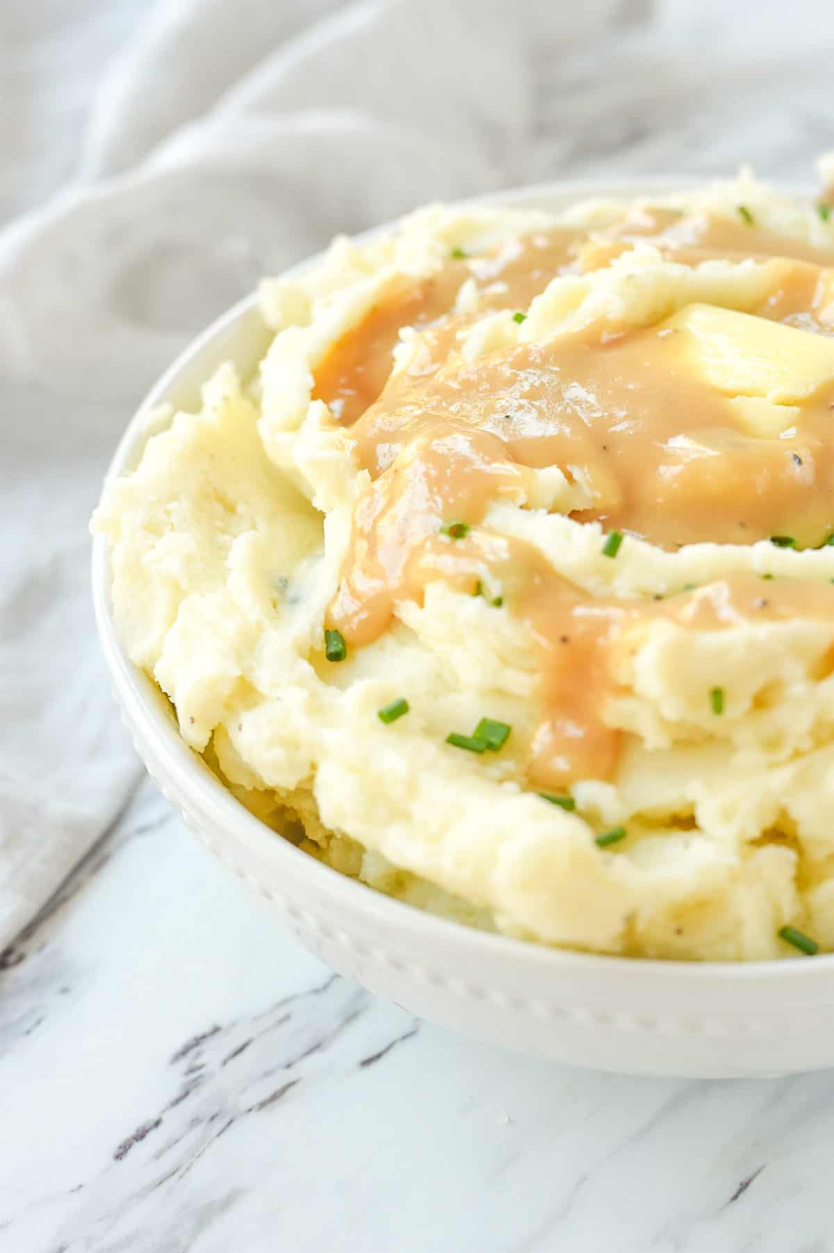 bowl of  mashed potatoes with gravy on top