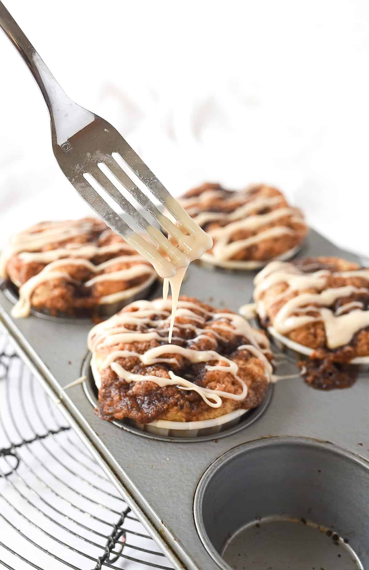 drizzling cinnamon roll muffins with glaze