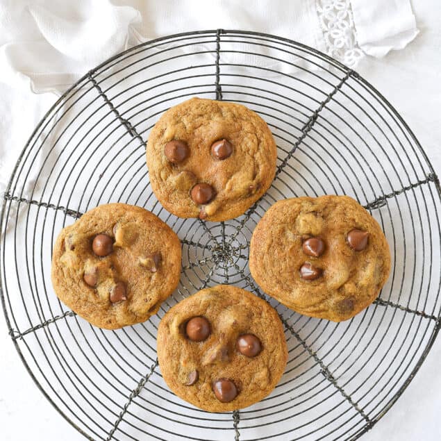four pumpkin cookies on a cooling rack