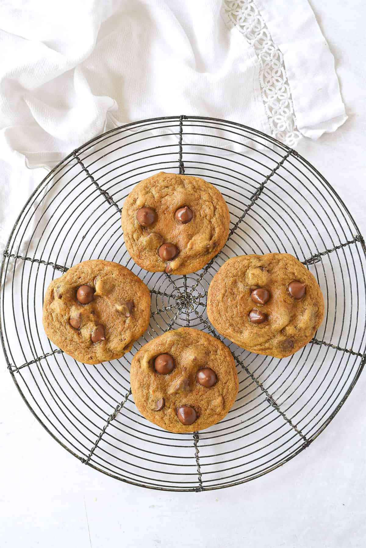 four pumpkin cookies on a cooling rack