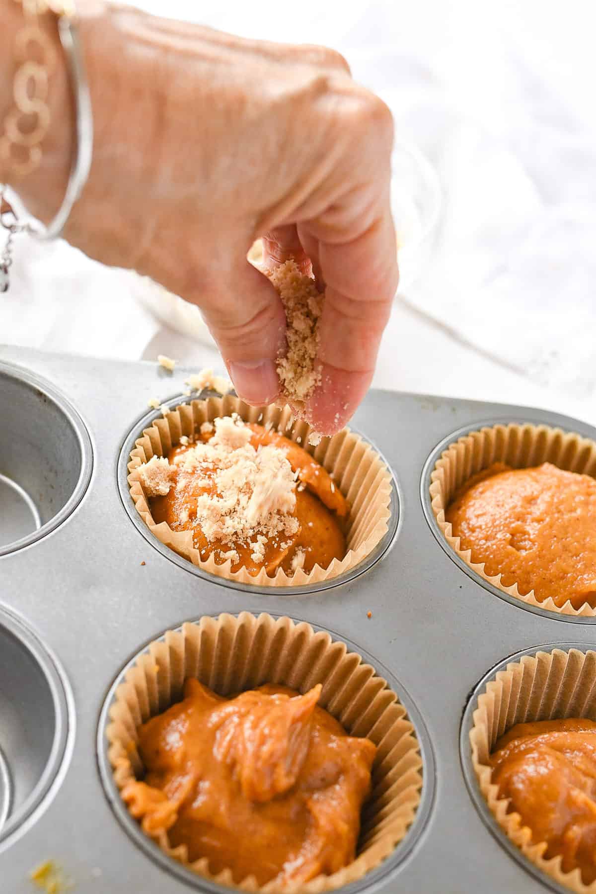 sprinkling streusel on muffin