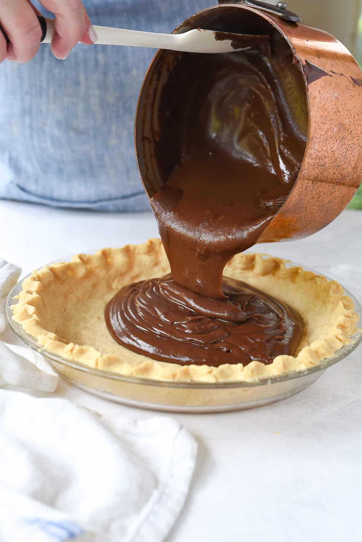 pouring chocolate filling into pie crust