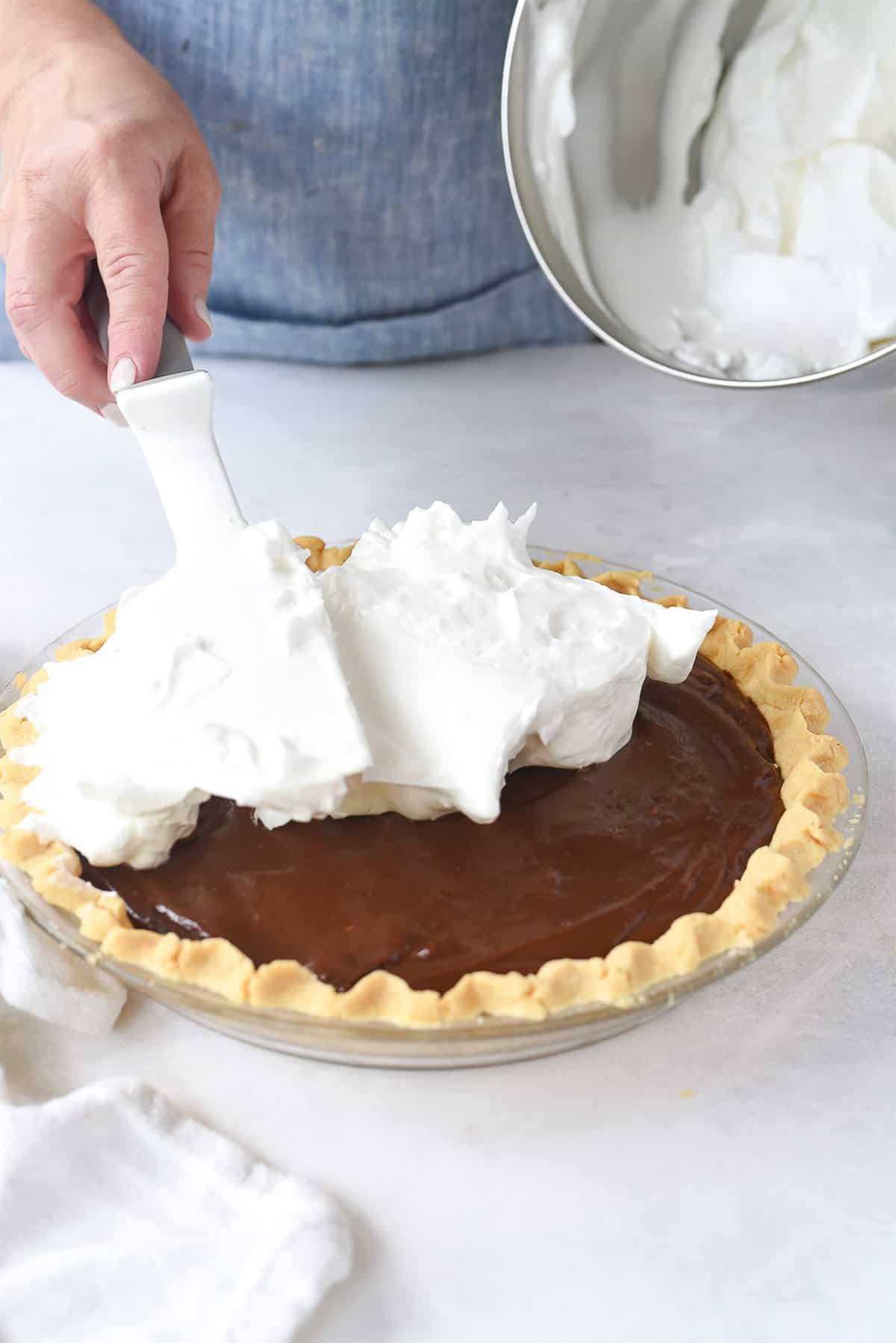 spreading meringue on chocolate pie