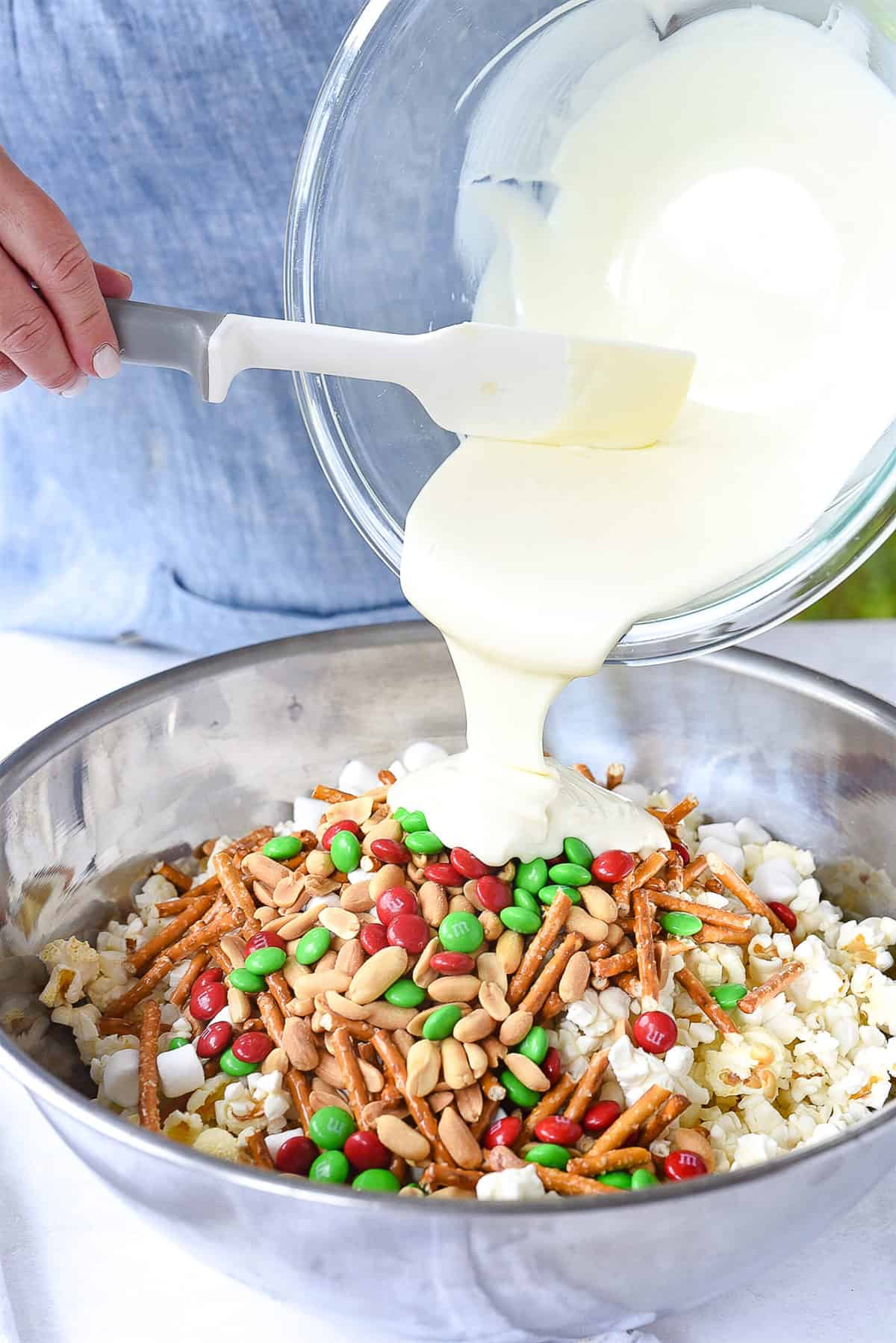 pouring white chocolate over popcorn