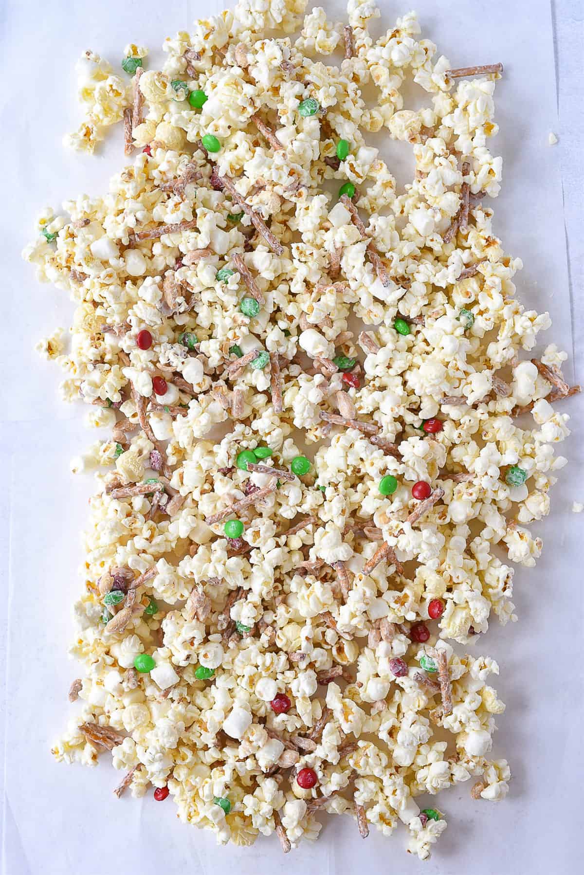 white chocolayte popcorn spread out on parchment paper