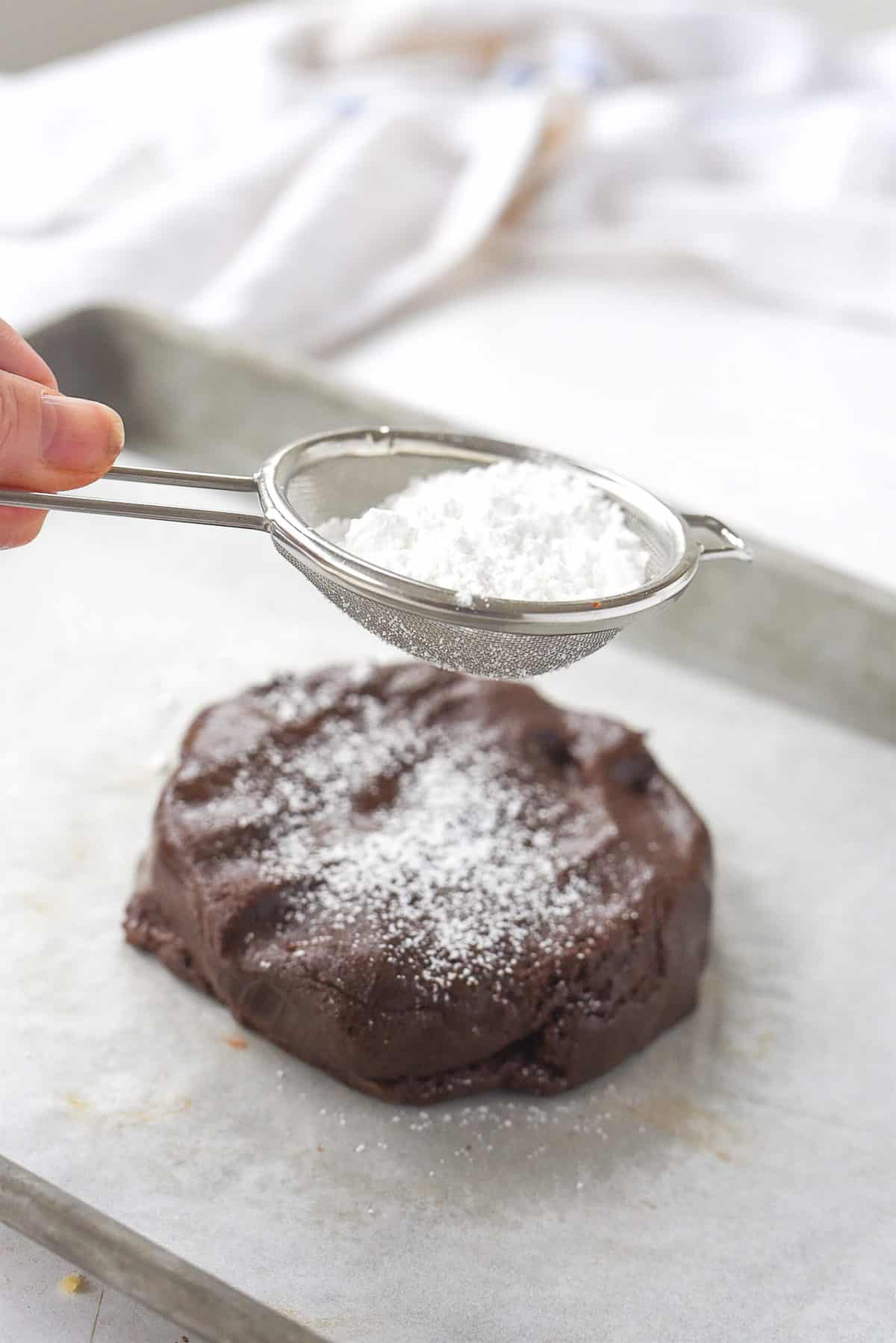 sprinkling cookie dough with powdered sugar
