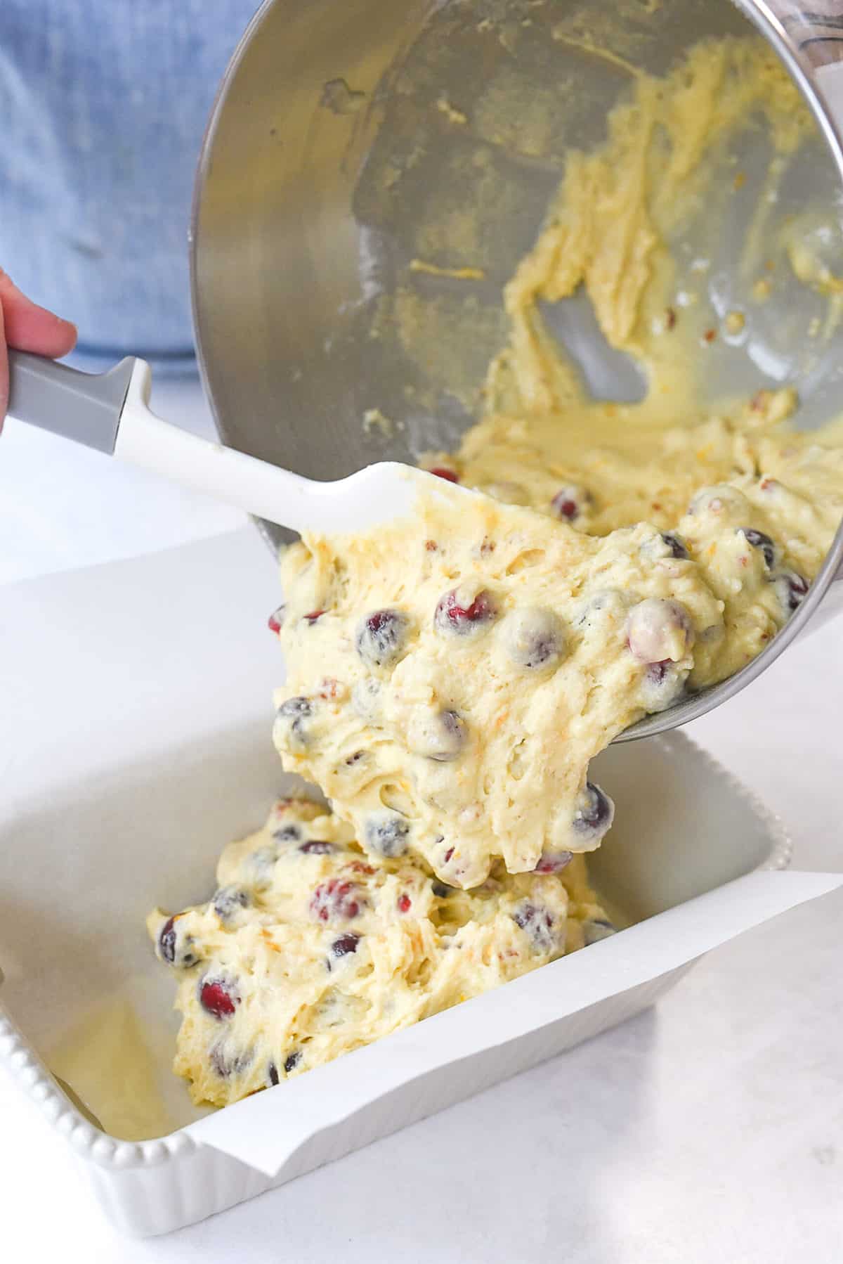 pouring bread batter into pan