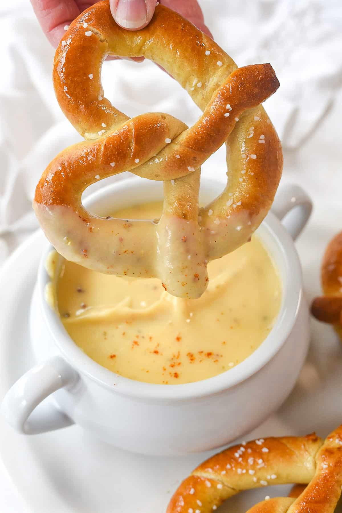 dipping pretzel in cheese sauce.