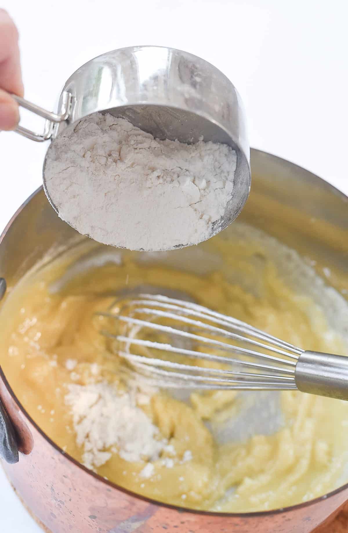 adding flour to a pan