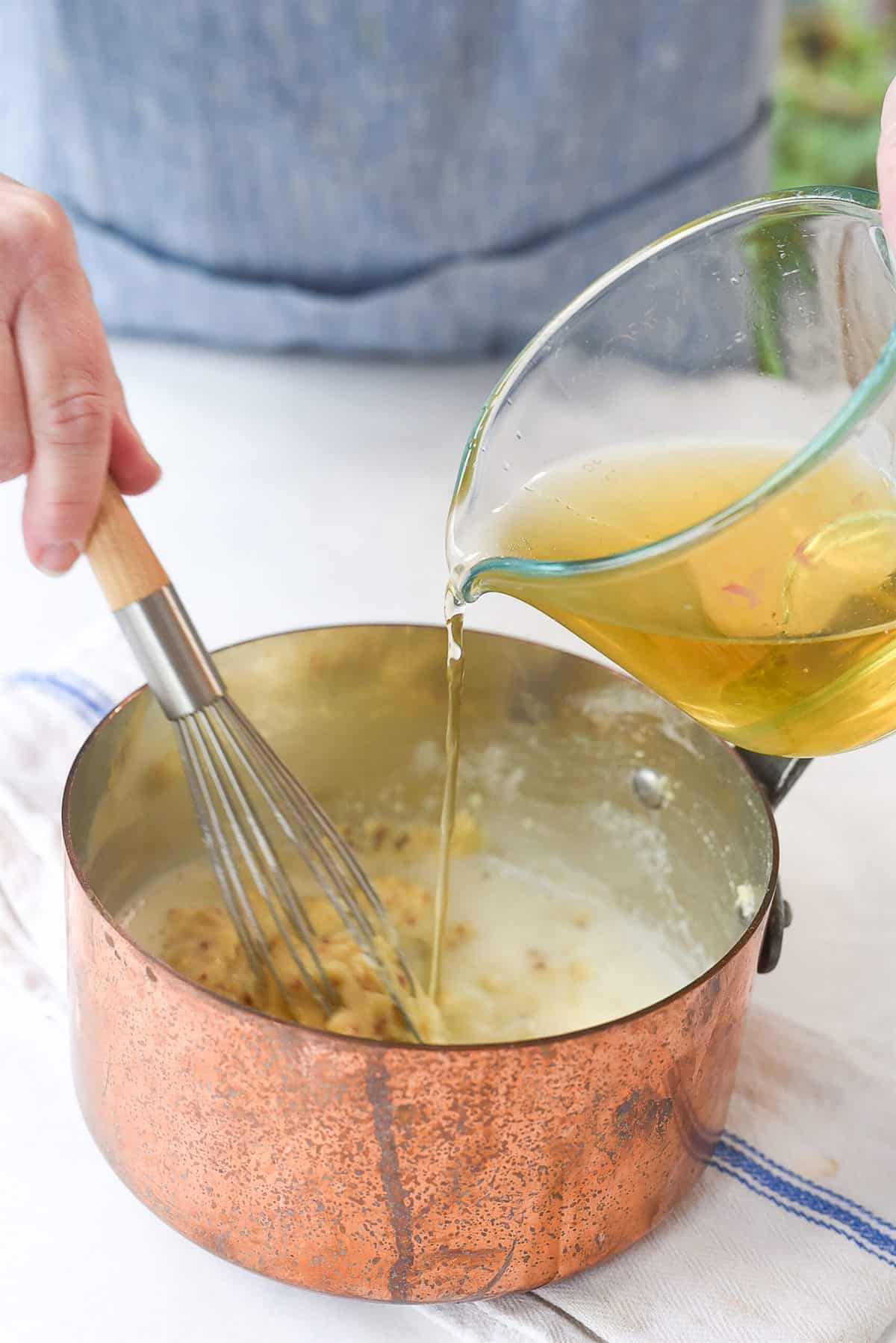 adding beer to pretzel dipping sauce