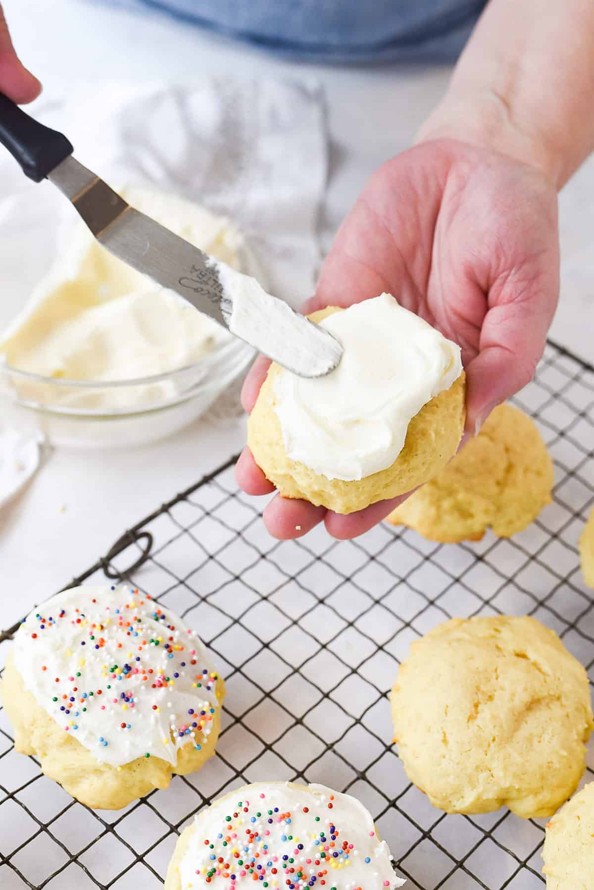 spreading frosting on sugar cookies
