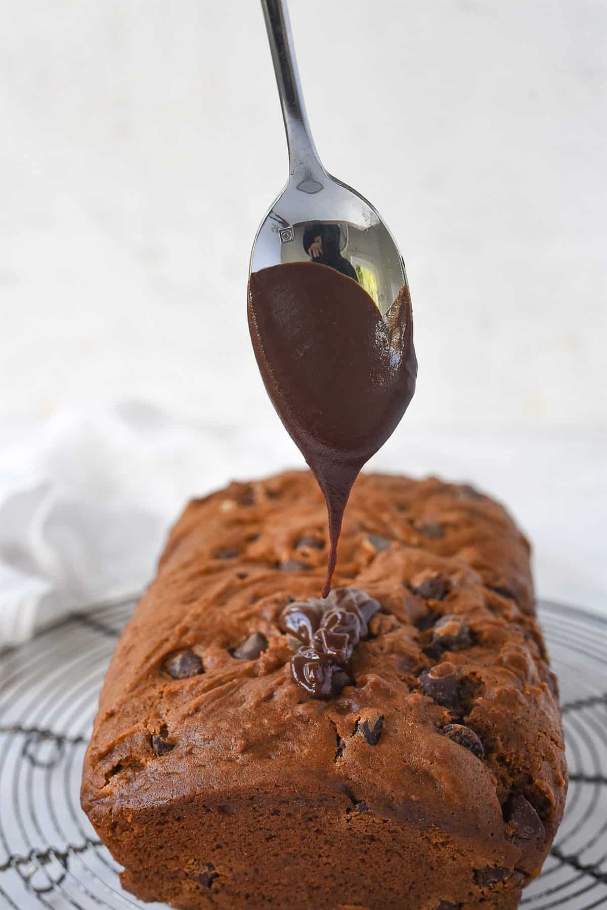 drizzling chocolate glaze on chocolate bread