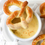 bowl of cheese sauce and pretzel