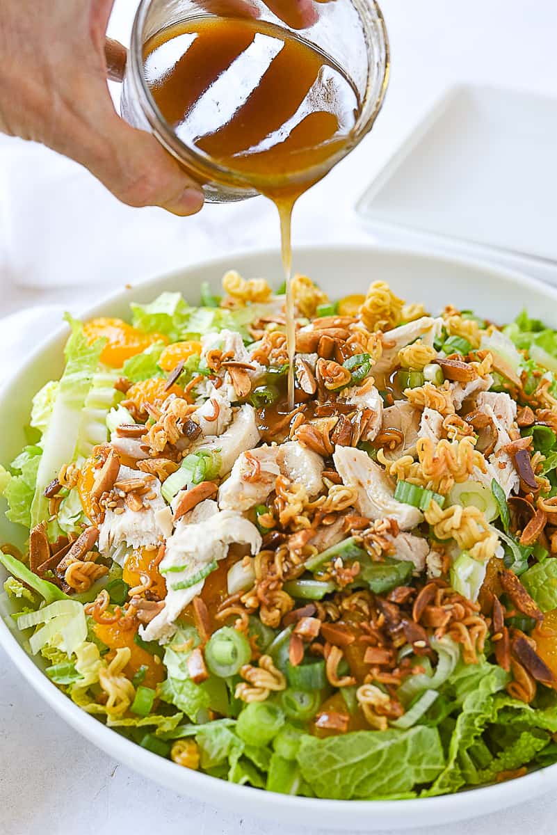 pouring dressing on napa chicken salad